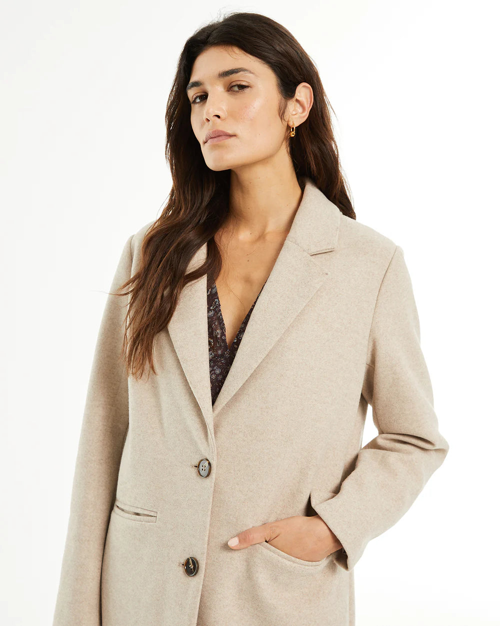 Abrigo de mujer de largo medio con solapa y cierre de botones — vista frontal en modelo