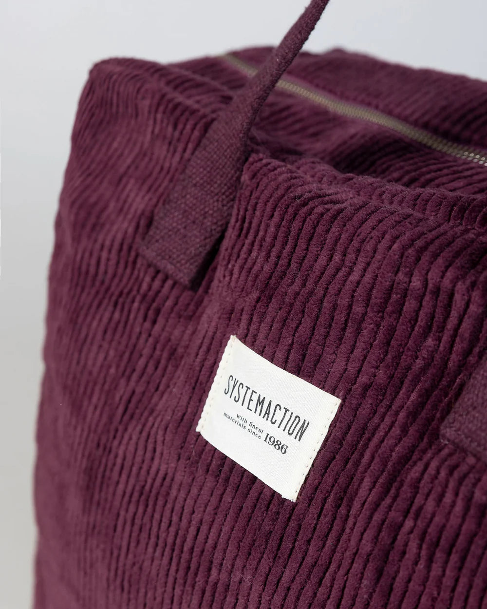 Detalle de textura de pana y etiqueta System Action