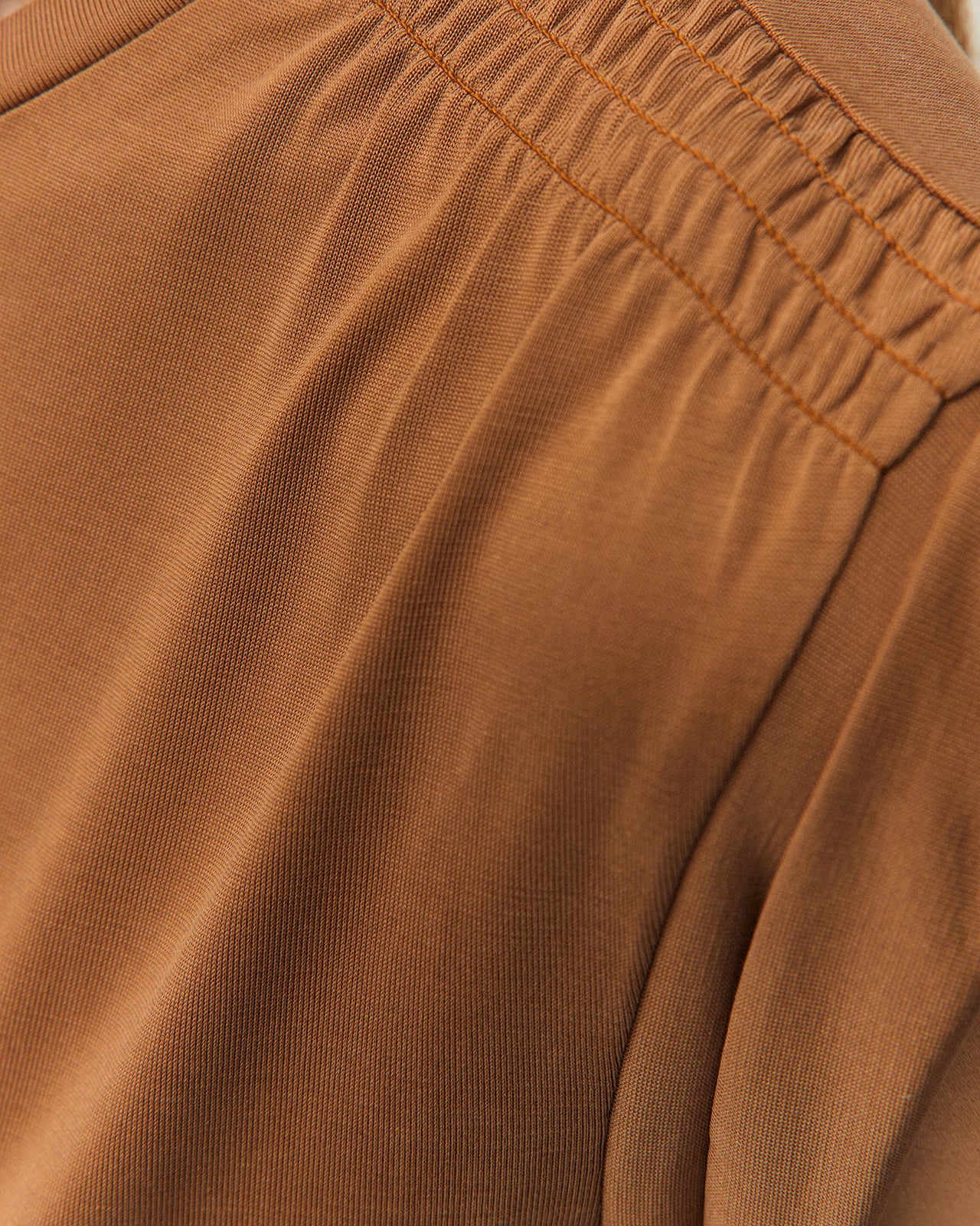 Detalle lateral de camiseta camel System Action con manga corta