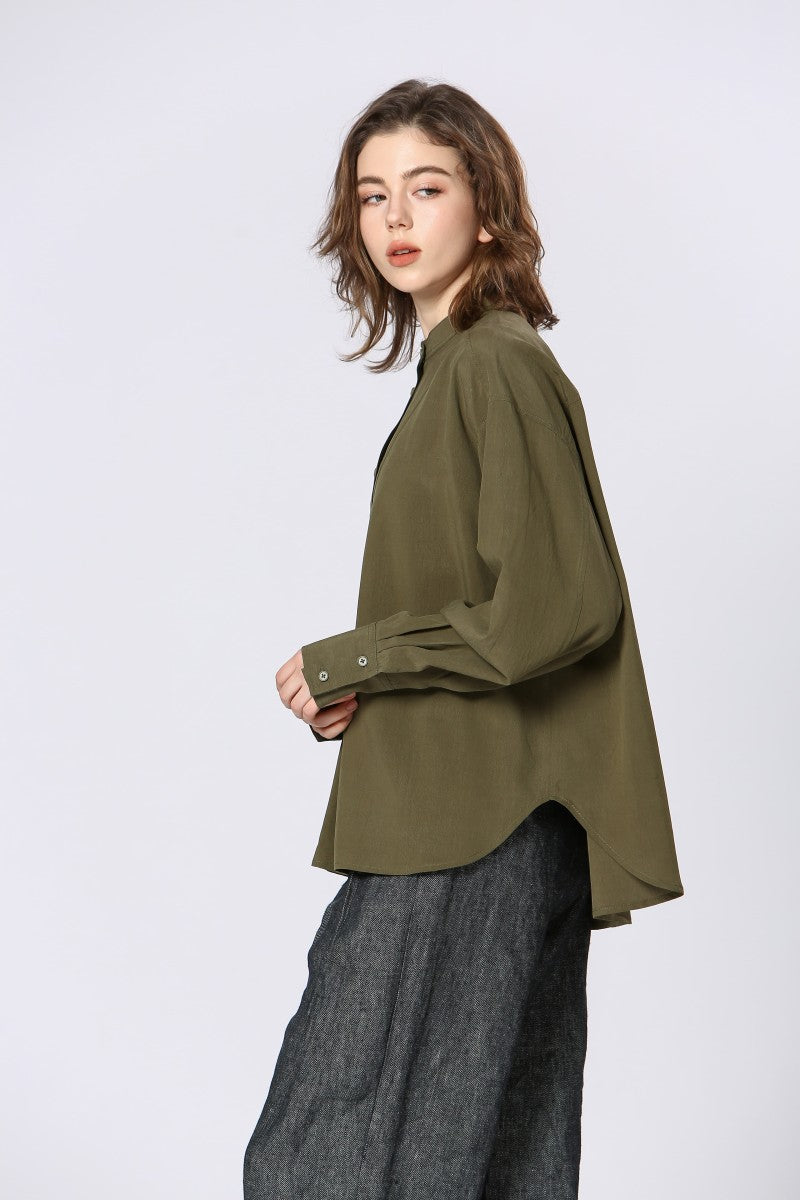 Vista lateral de la blusa con bajo redondeado y manga larga con puño